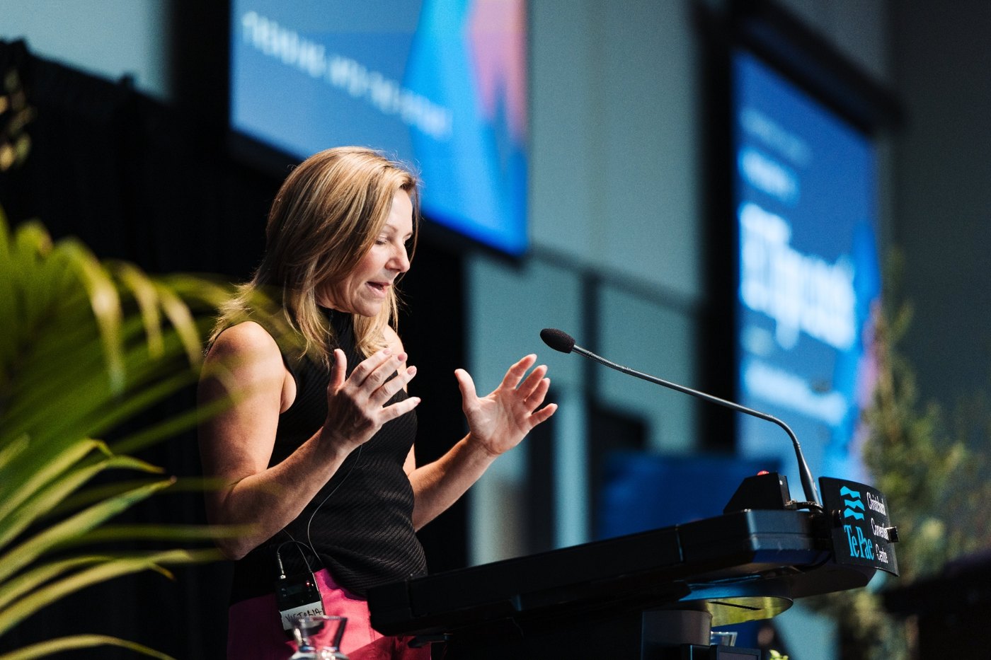 Dr Victoria Hatton presenting from a lectern, mid gesture